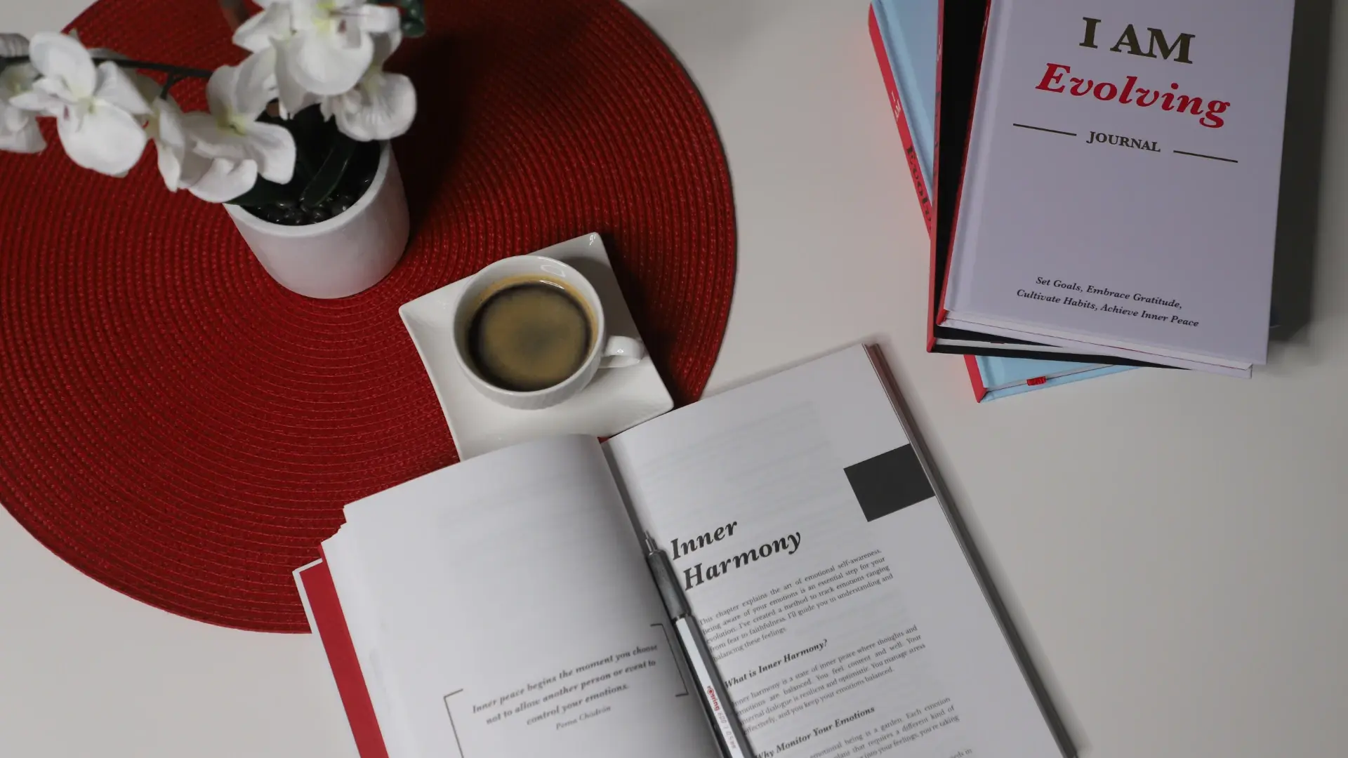iAmEvolving Journal surrounded by other personal development journals on a wooden desk.