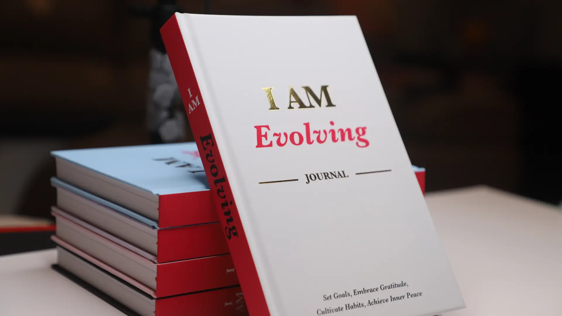 iAmEvolving Journal – hardcover gratitude and goal-setting journal for women, featuring a white and red cover with the title “I AM Evolving.