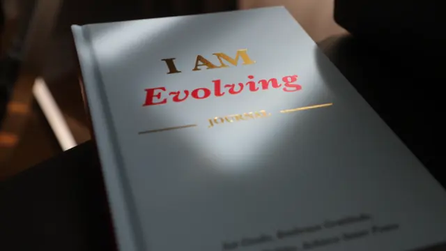 iAmEvolving Journal on a clean desk with a pen, ready for a beginner journaling session.