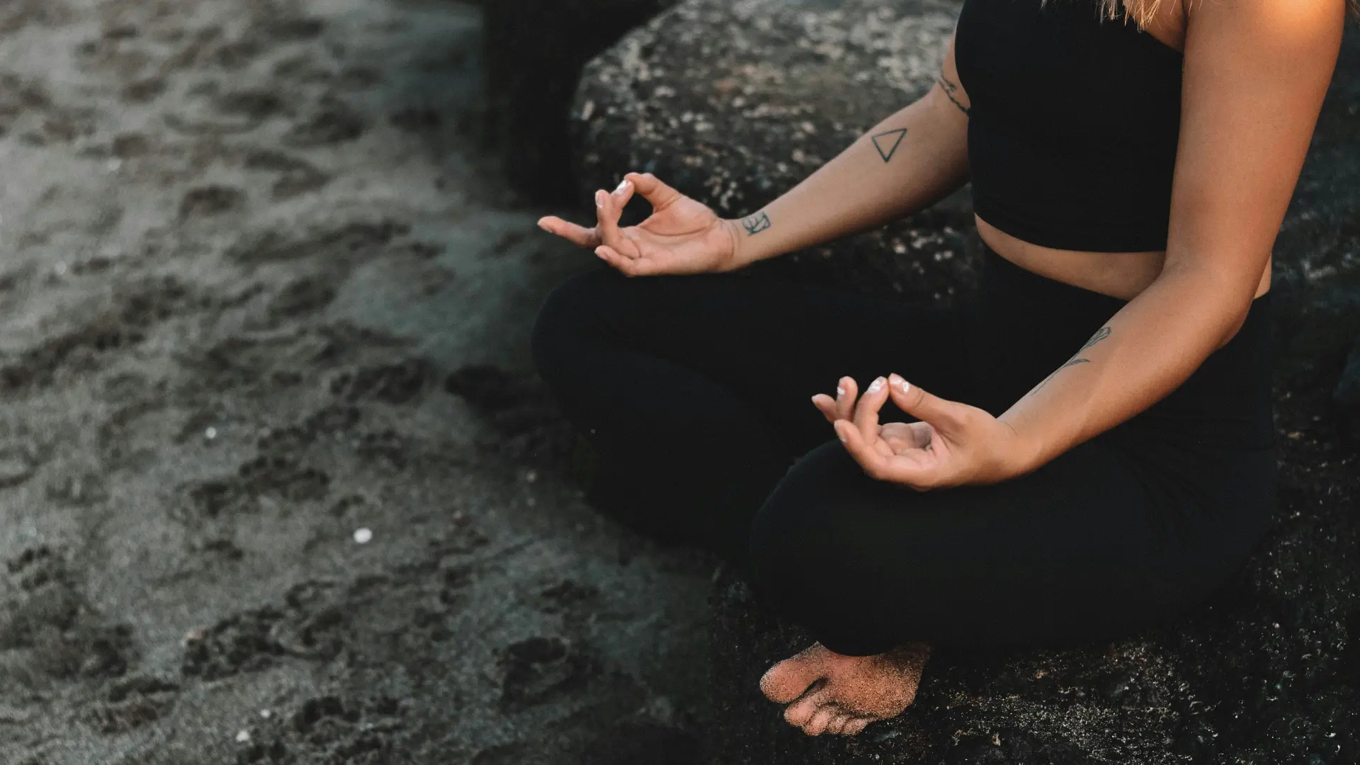 Woman meditating on the beach, reconnecting with herself through mindfulness.