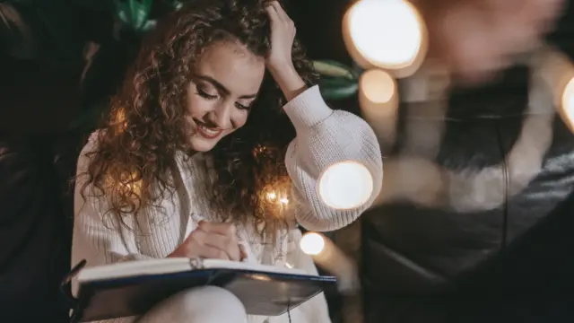 Woman journaling, reflecting on self-care and mindfulness