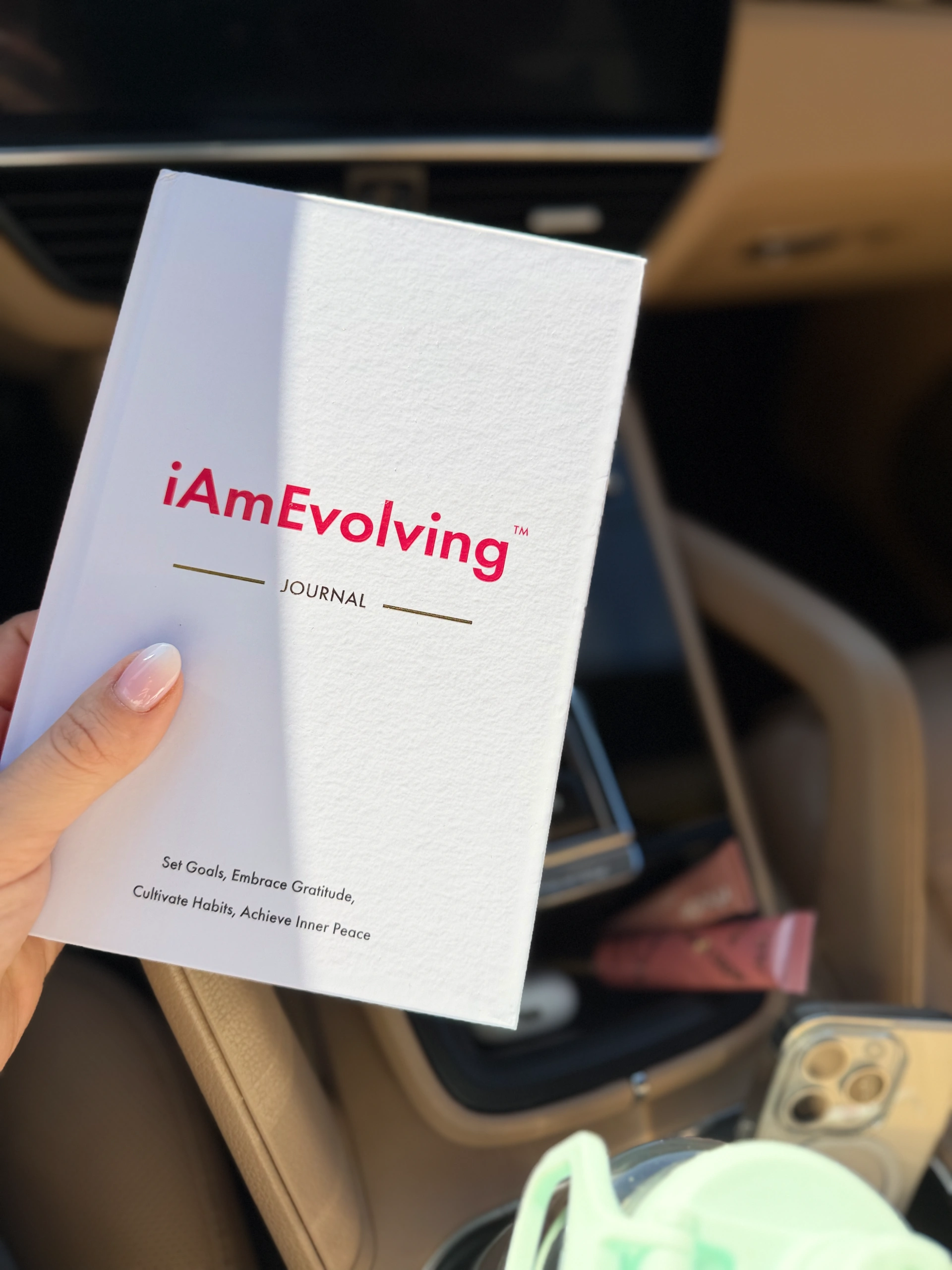 iAmEvolving Journal, a minimalist gratitude journal with a white hardcover, designed for daily gratitude writing, goal setting, habit tracking, and inner reflection.