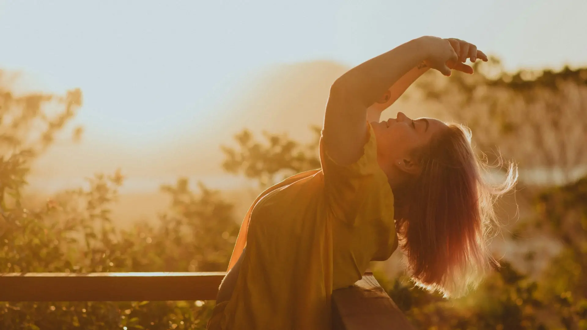 Woman stretching in morning sunlight, representing the Affirmations Guide practice of mindful self-talk and emotional renewal