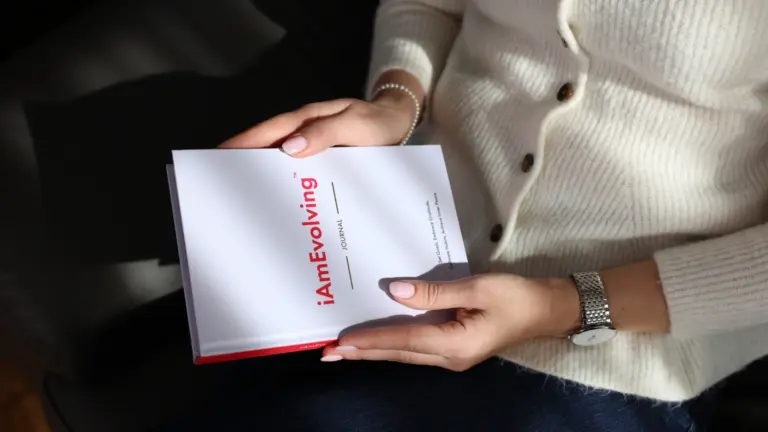 Close-up of hands holding the iAmEvolving Journal, symbolizing mindful daily routines and personal growth practices.