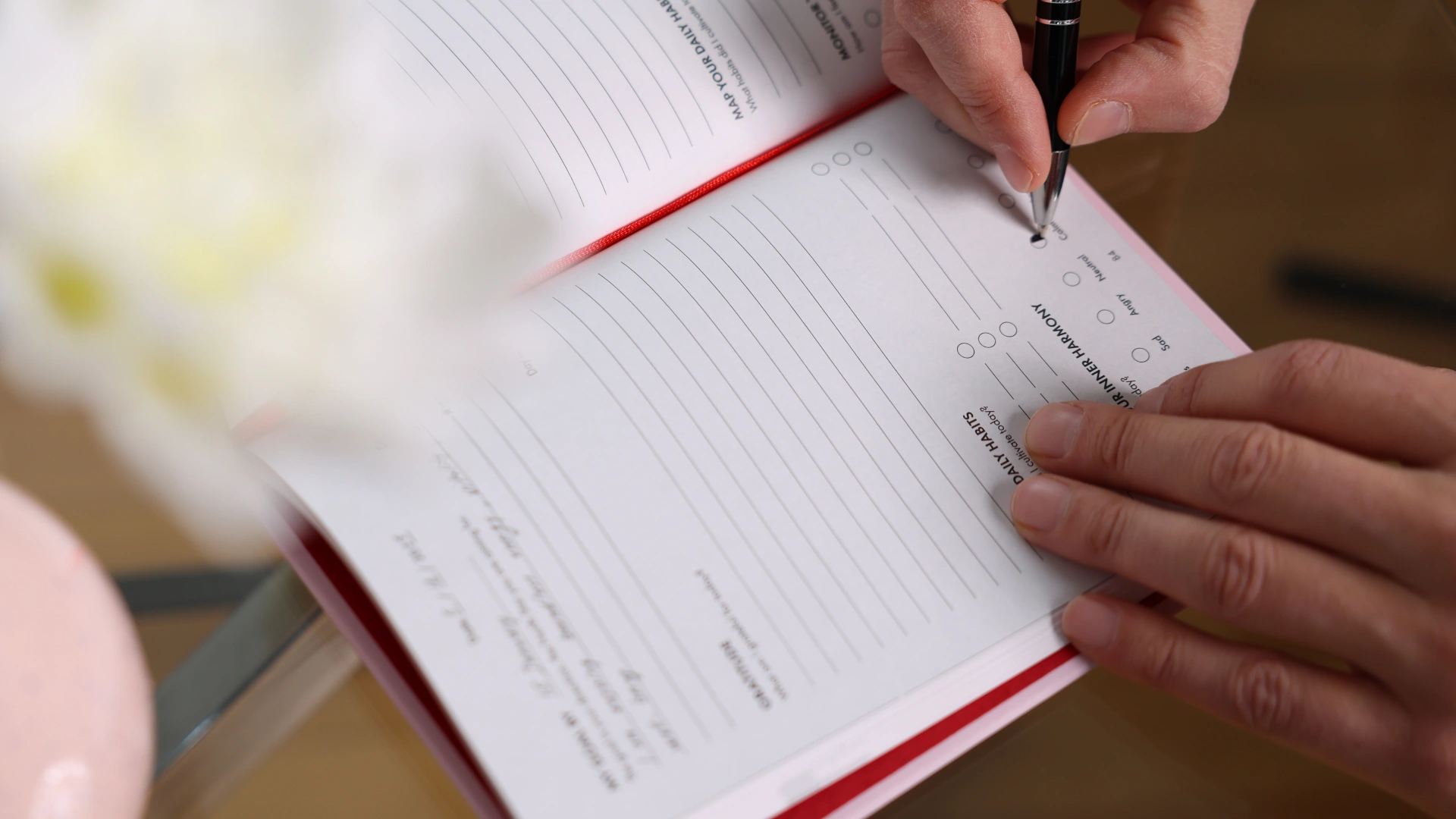 Hands journaling on the Inner Harmony tracking page, marking emotional states to reflect on feelings and awareness.