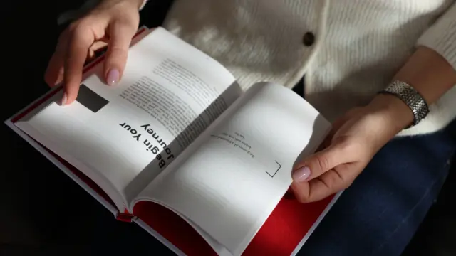 Person opening a journal with the words “Begin Your Journey,” symbolizing mindfulness, clarity, and personal growth through journaling.