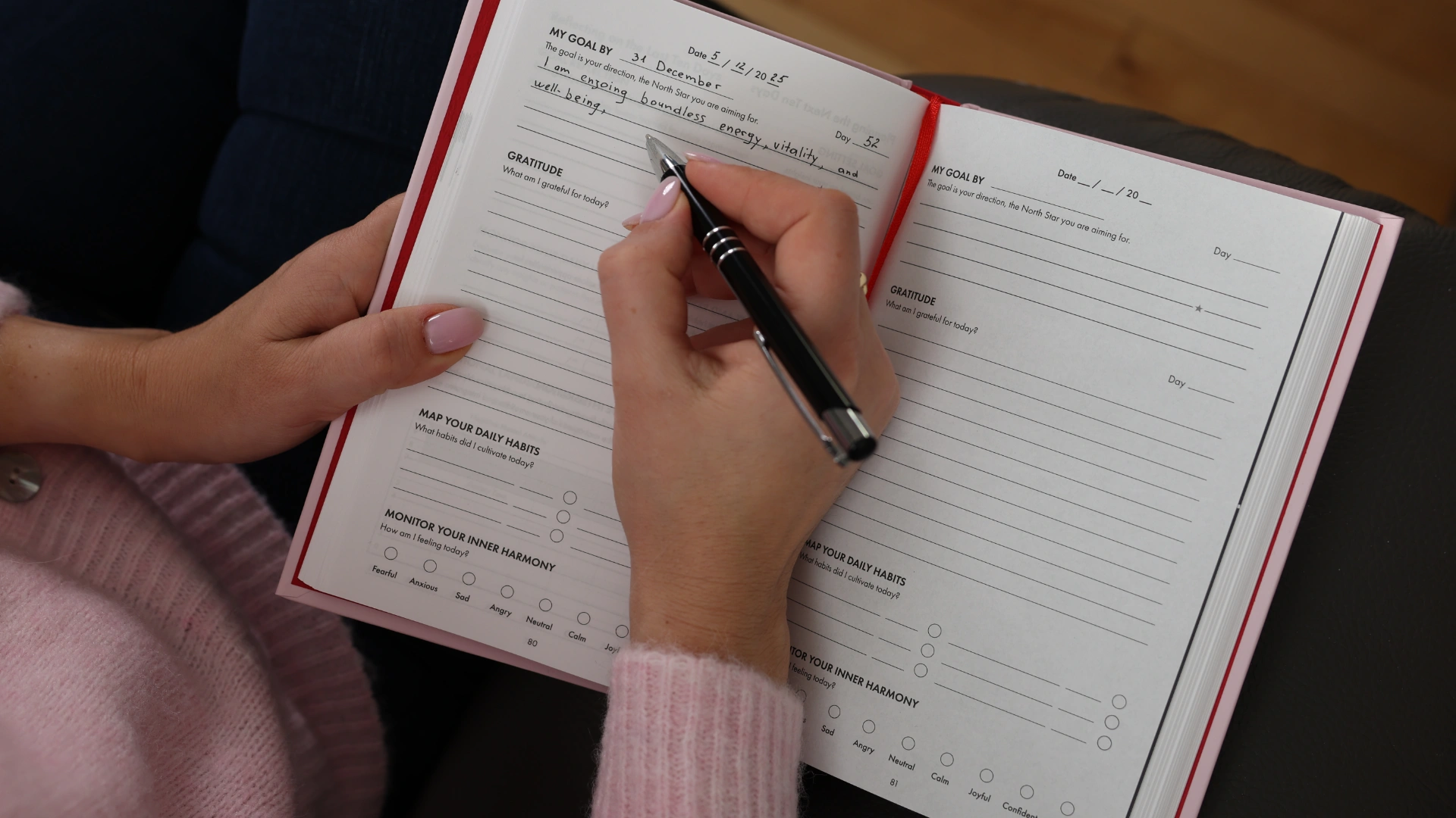 Person writing goals and gratitude in a daily journal — mindful planning and reflection for inner peace.