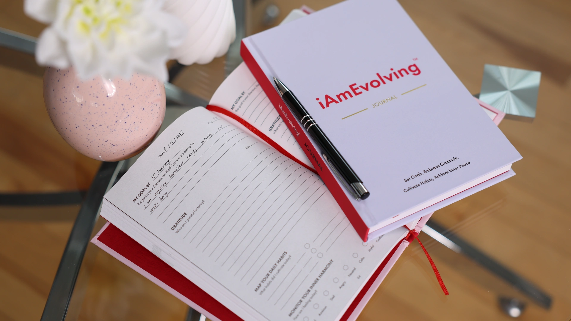 iAmEvolving Journal open on a table with a pen, symbolizing reflection, clarity, and personal growth.