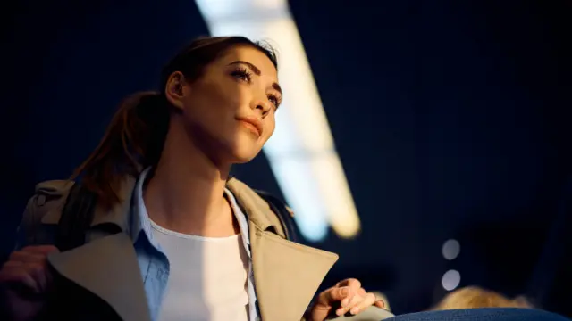 Woman looking upward with thoughtful expression, symbolizing inner clarity and perspective shifts in personal growth.