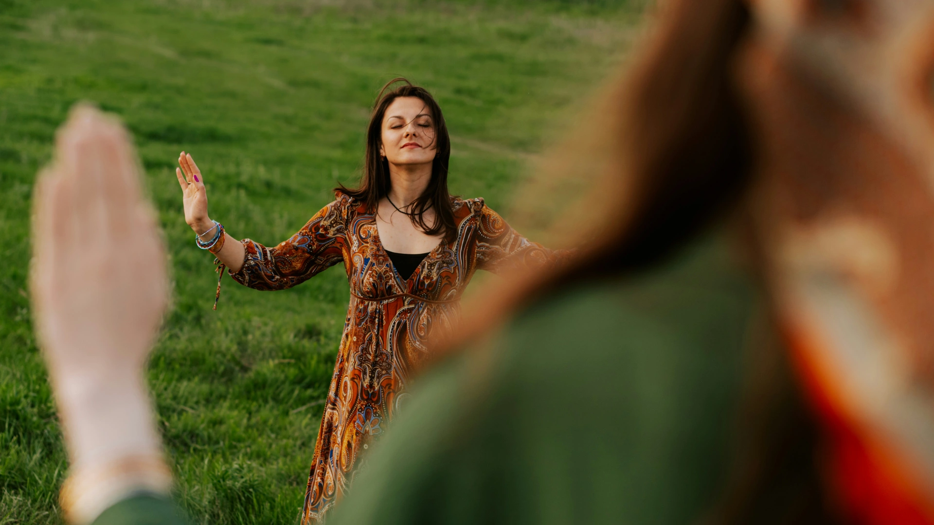 Person standing calmly in nature with open hands, symbolizing emotional regulation and inner balance.