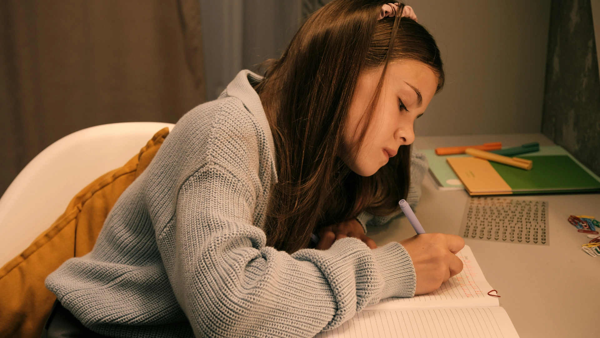 Woman journaling quietly at a desk, writing in a notebook as a grounding practice for anxiety