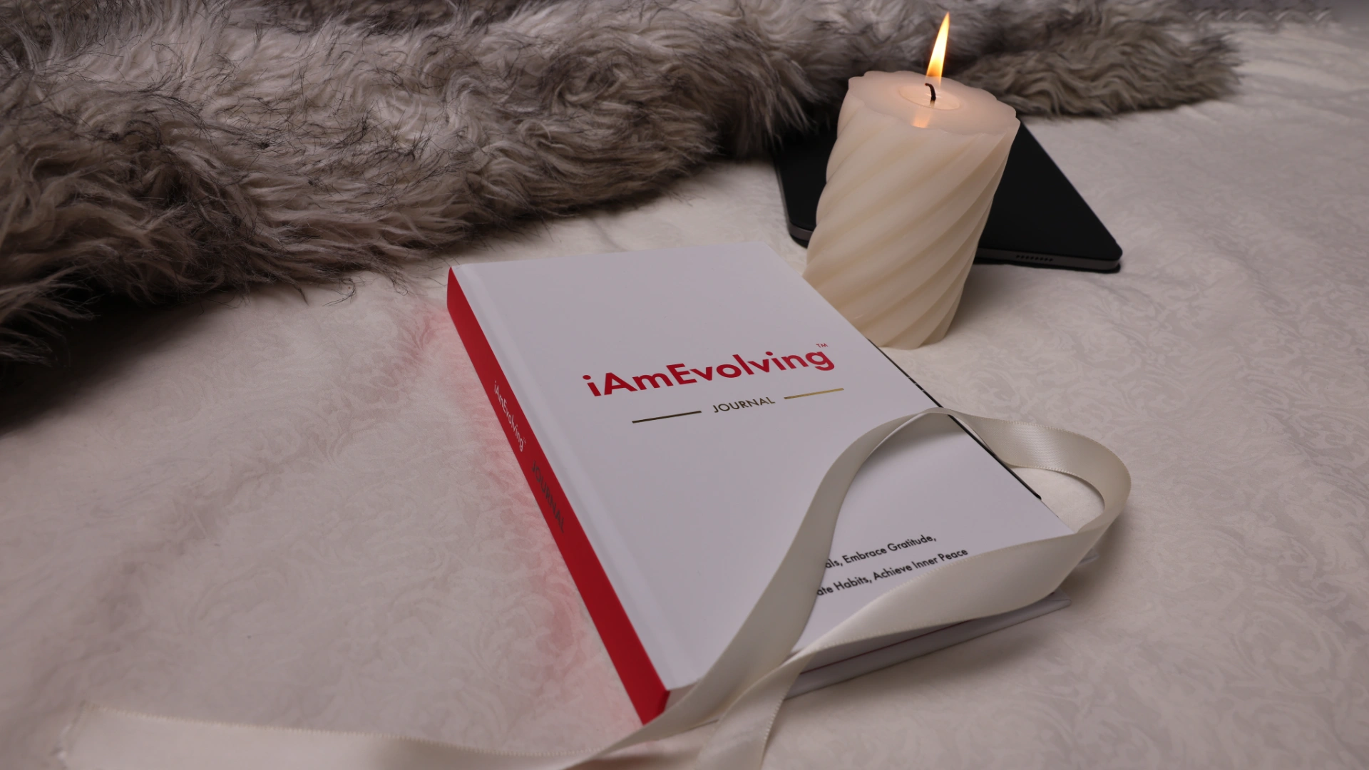 iAmEvolving Journal with candle and ribbon on soft blanket – a top rated gratitude journal for mindful reflection
