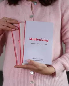 Woman holding iAmEvolving Journals in rose and white