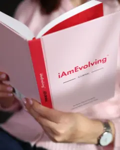 iAmEvolving Journal white edition held open showing cover and red spine