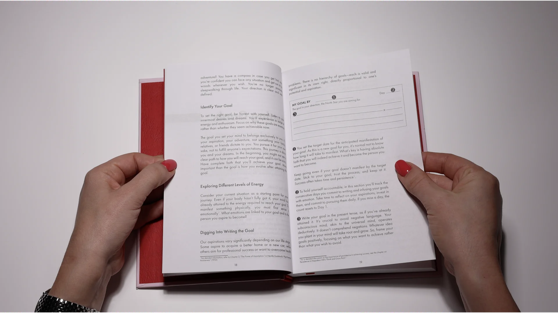 Hands holding open journal showing goal-setting pages — the science behind journaling